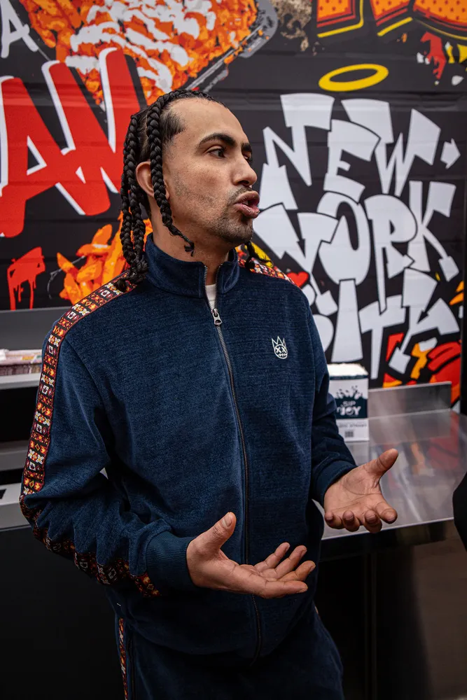 Portrait of a man gesturing in front of a colorful graffiti wall