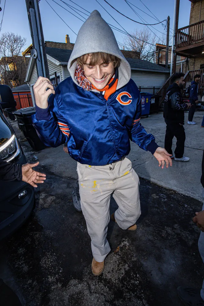 Person in a blue jacket standing outside near a storefront