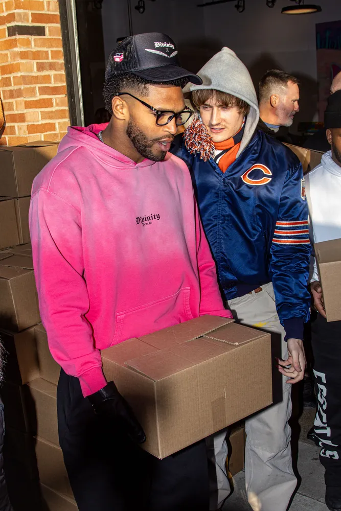 Two people posing together with a box outside a storefront