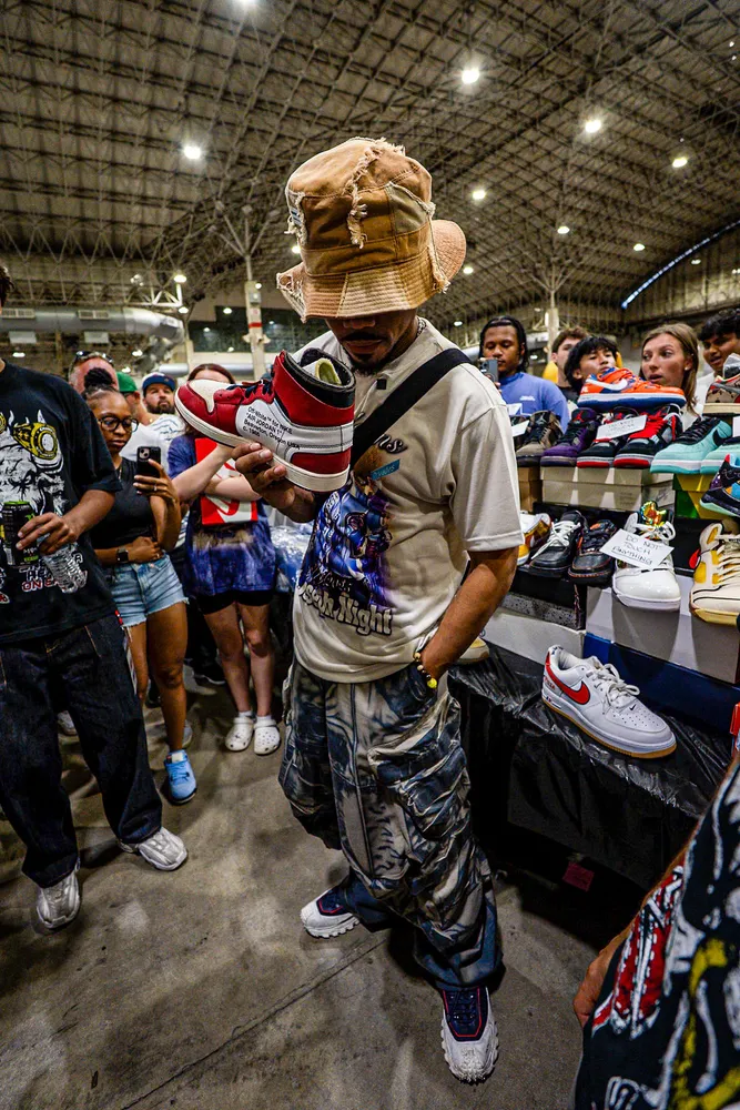 Full-length portrait at a crowded indoor sneaker event