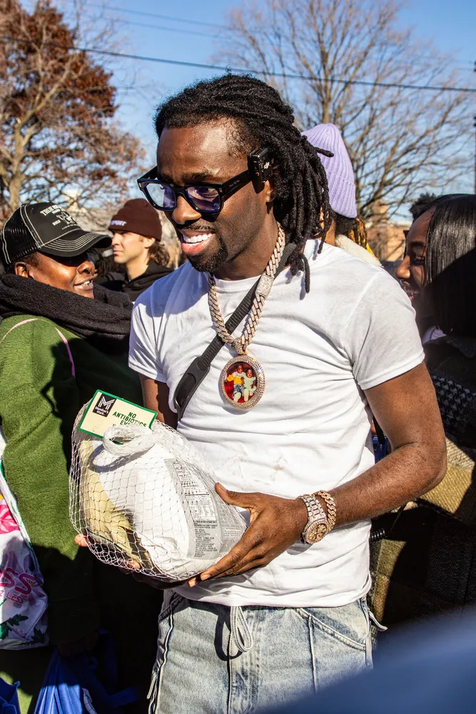 Portrait of a smiling man in sunglasses surrounded by people outdoors