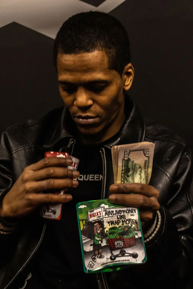 Portrait of a man holding printed items in a dark setting