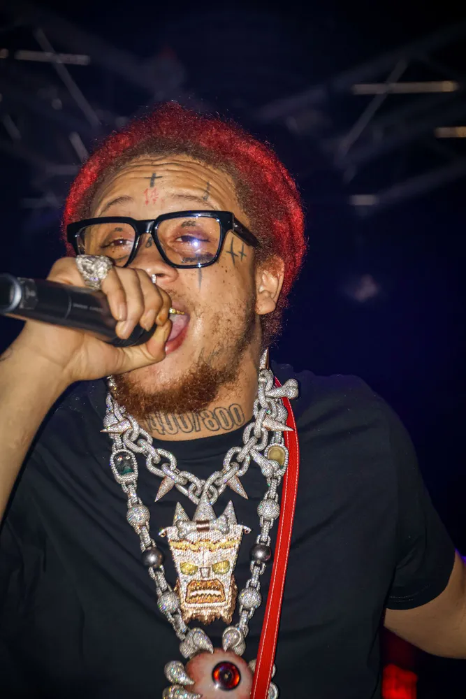 Red-haired performer singing into a microphone at close range