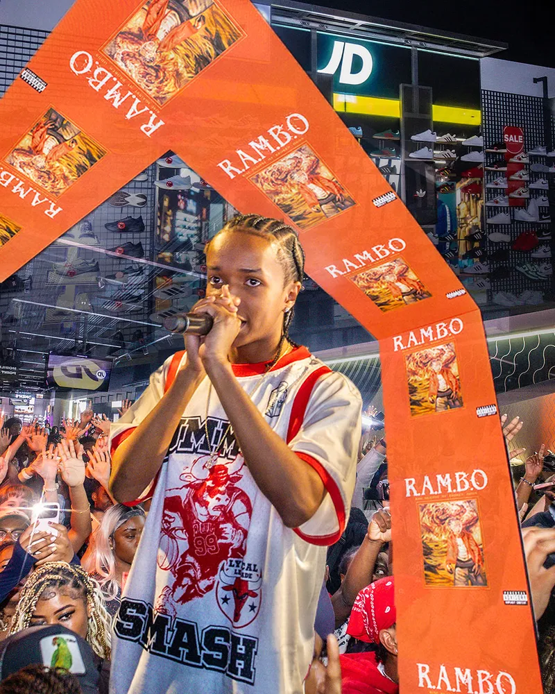 Concert artwork with orange graphic elements and a performer