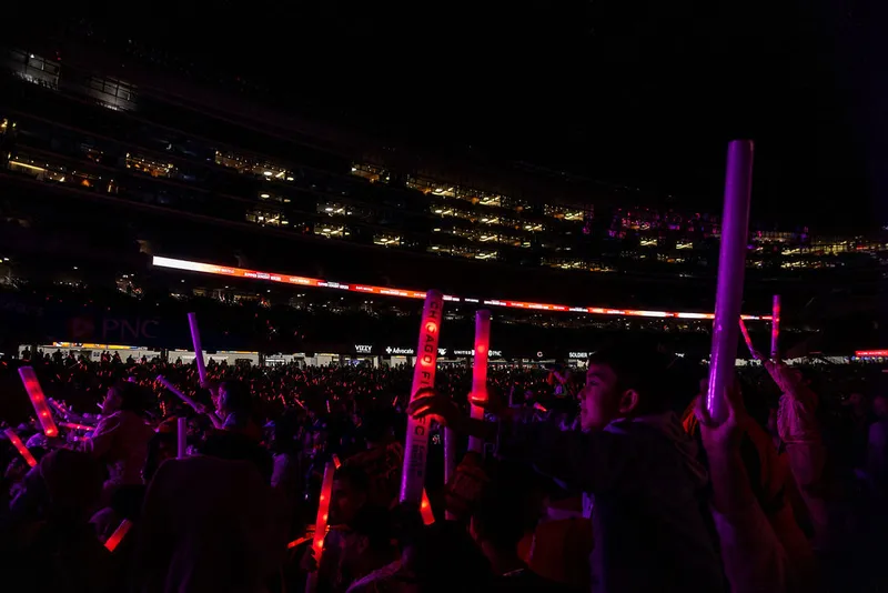 Wide view of a concert audience illuminated by purple lights