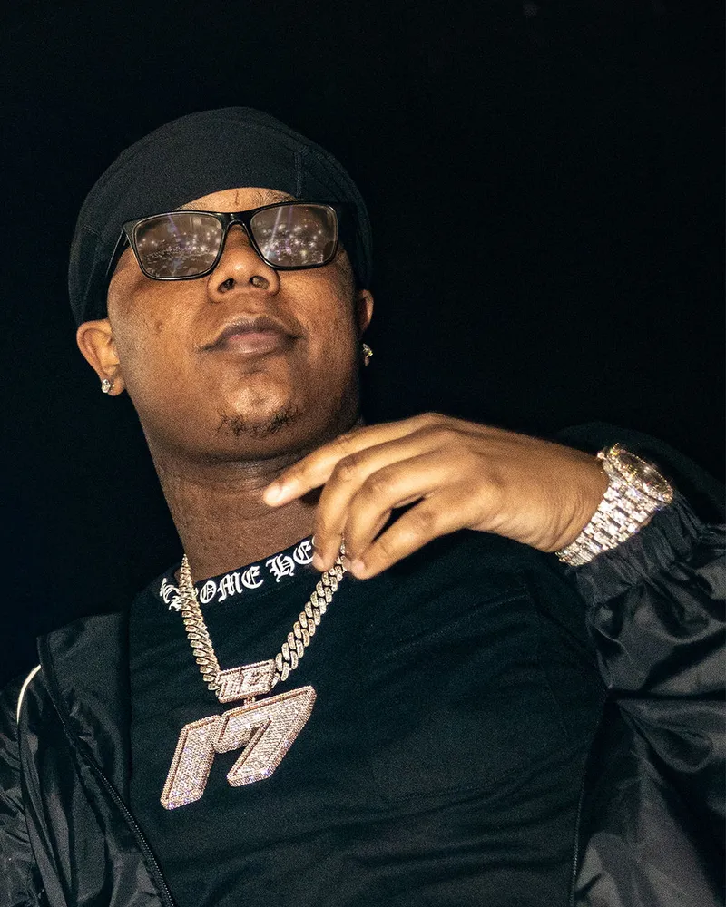 Close-up portrait of a performer wearing glasses and a cap