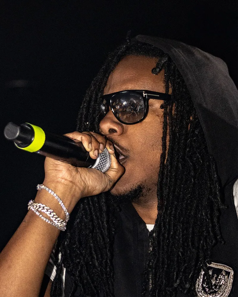 Close-up of a performer in sunglasses holding a microphone