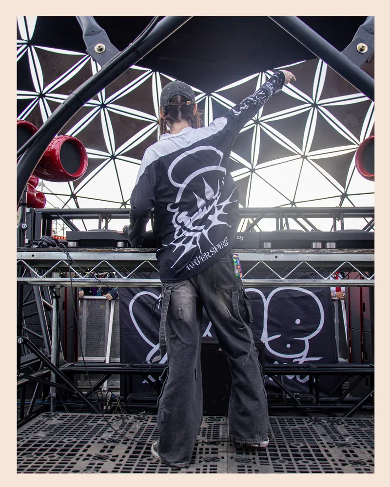 Black-and-white portrait of a performer beneath stage trusses