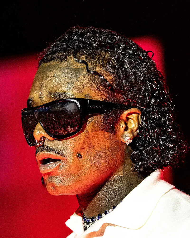 Close-up performance portrait with sunglasses and red lighting