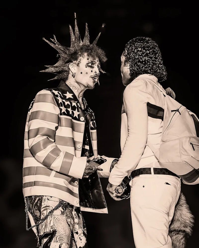 Black-and-white portrait of two performers facing one another