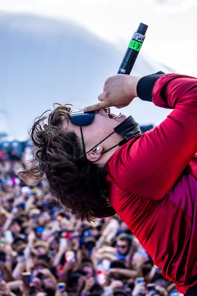 Performer in red leaning back above a festival crowd