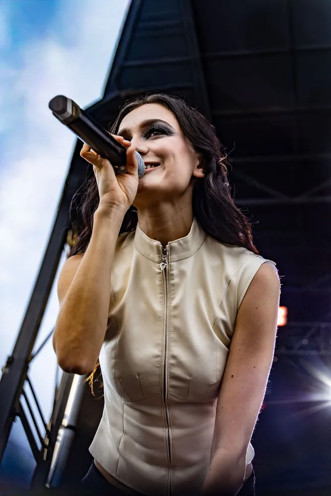 Singer performing at an outdoor festival in daylight